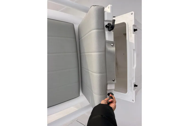 Slide: The Image of 2022 Aquasport 2500 Center Console seat storage compartment with gray cushioned cover. - 20