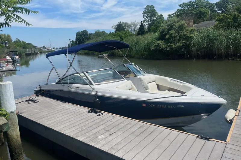 Slide: The Image of 2018 Cobalt R3 boat docked on a calm river with lush greenery. - 2