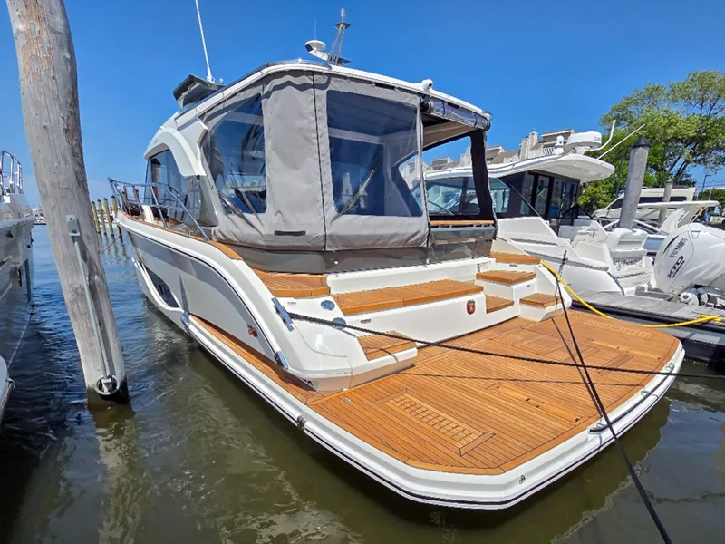 Slide: The Image of 2026 Marex 440 yacht docked, featuring sleek design and spacious wooden deck. - 13