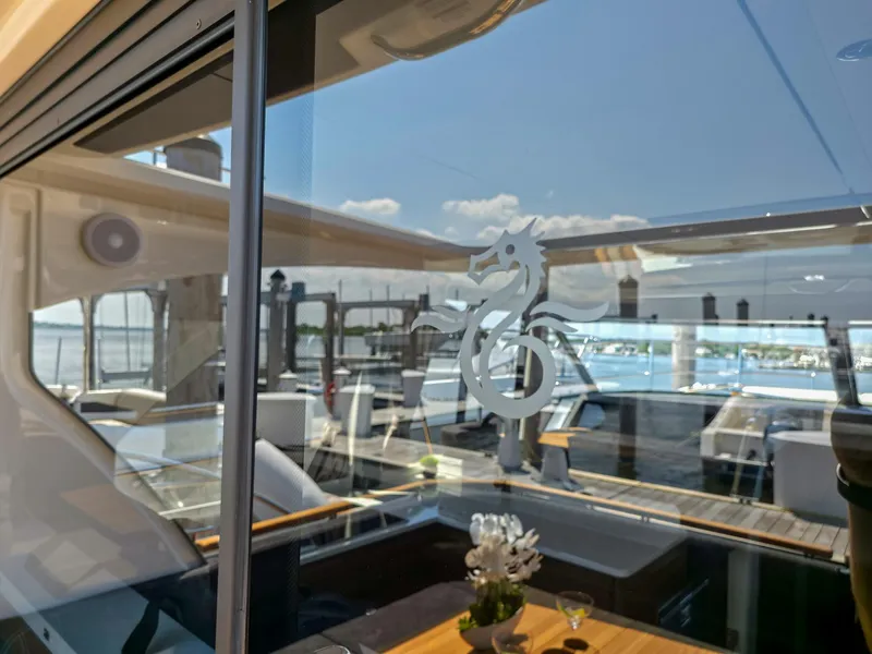 Slide: The Image of 2026 Marex 440 yacht interior with seahorse logo on glass, docked at marina. - 23