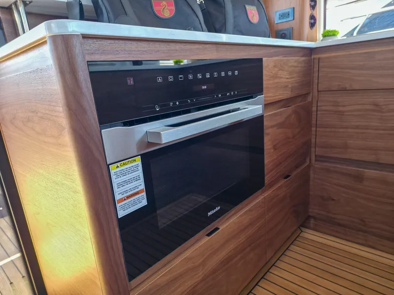 Slide: The Image of Modern kitchen with Miele oven in 2026 Marex 440 yacht, featuring sleek wood cabinetry. - 34