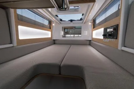 Slide: The Image of 2023 Axopar 28 Cabin interior with luxurious teal seating and quilted design. - 10