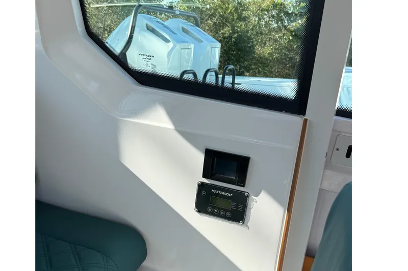 Slide: The Image of 2023 Axopar 28 Cabin interior with teal quilted seating and cushions. - 12