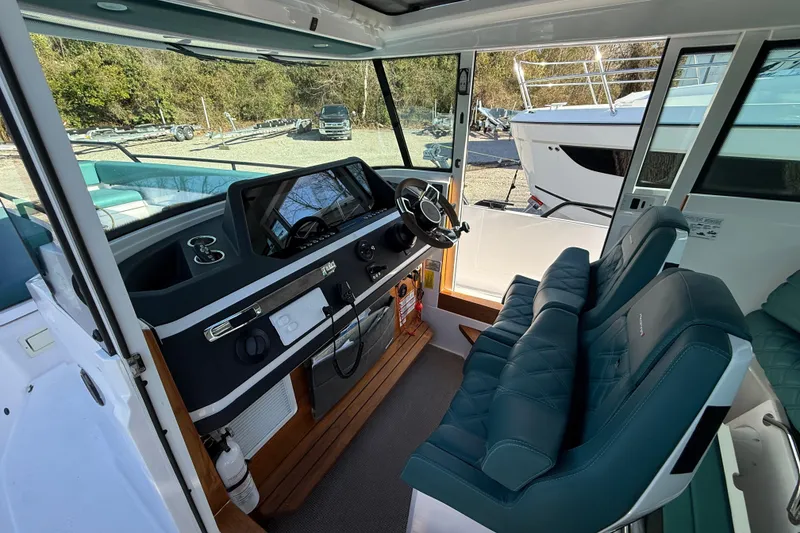 Slide: The Image of 2023 Axopar 28 Cabin interior storage with equipment and life jacket. - 14