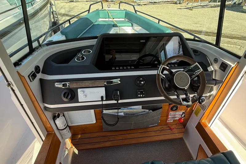 Slide: The Image of 2023 Axopar 28 Cabin boat with open cabin door revealing interior. - 17