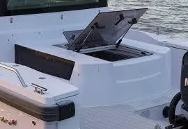 Slide: The Image of Axopar 28 Cabin 2023 with open storage hatch on the water. - 2