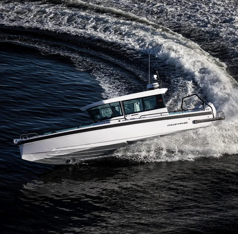 Slide: The Image of 2023 Axopar 28 Cabin boat cruising swiftly on water. - 5