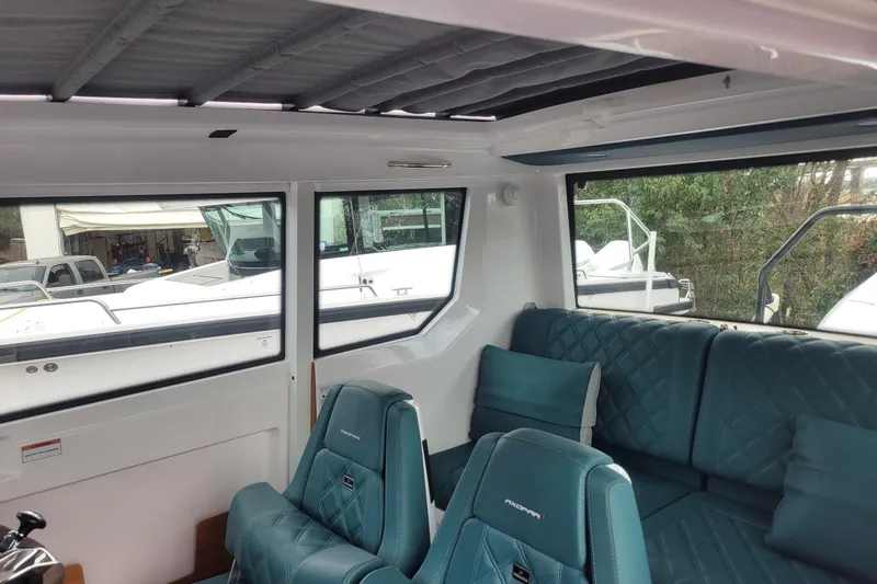 Slide: The Image of 2023 Axopar 28 Cabin helm with modern controls and steering wheel. - 8