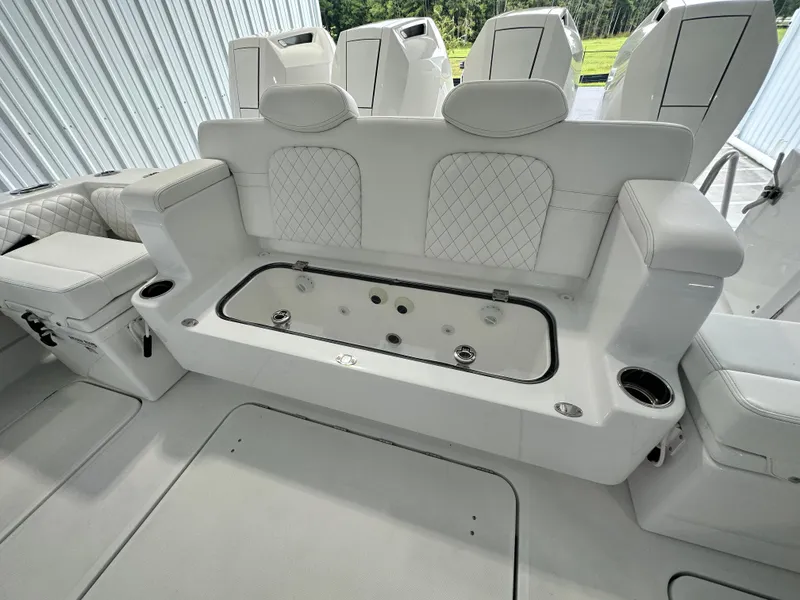 Slide: The Image of 2025 HCB Lujo boat interior with white seating and storage compartment. - 23