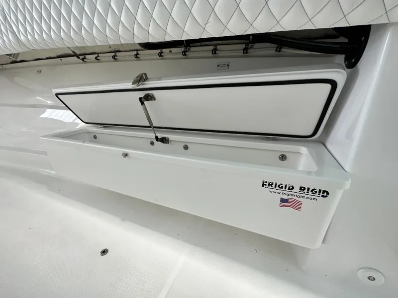 Slide: The Image of HCB Lujo 2025 boat storage compartment with Frigid Rigid cooler, featuring quilted upholstery. - 48