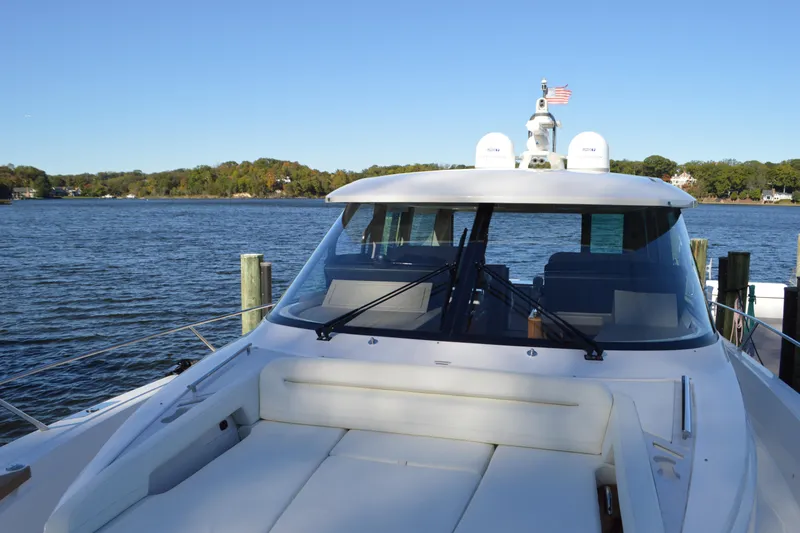 Slide: The Image of 2024 Tiara Yachts EX 60 luxury yacht docked by serene waters. - 11