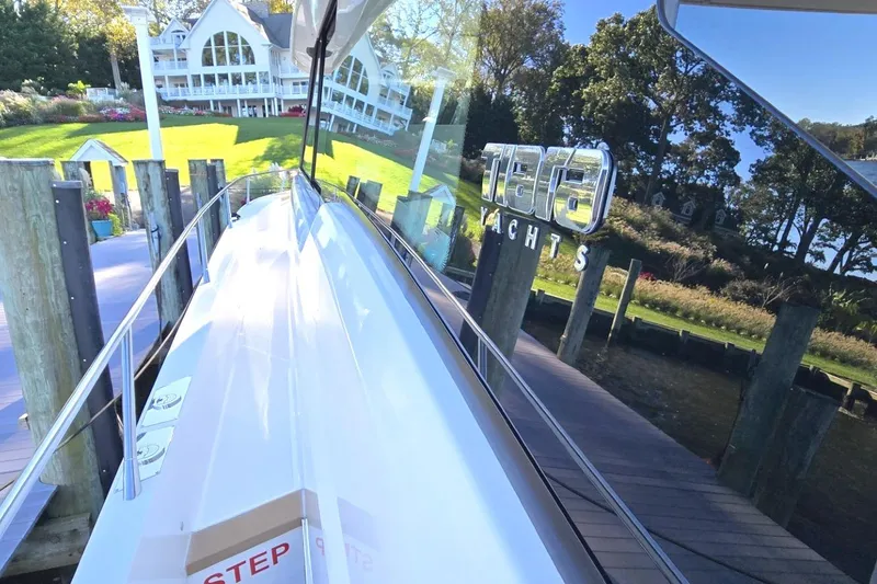 Slide: The Image of 2024 Tiara Yachts EX 60 docked near a scenic waterfront property. - 17