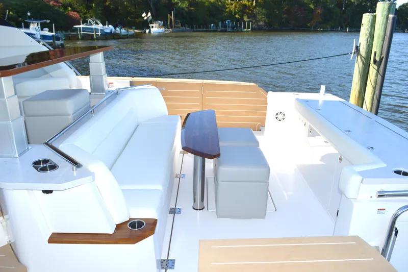 Slide: The Image of Luxurious 2024 Tiara Yachts EX 60 deck with elegant seating and table by the water. - 20