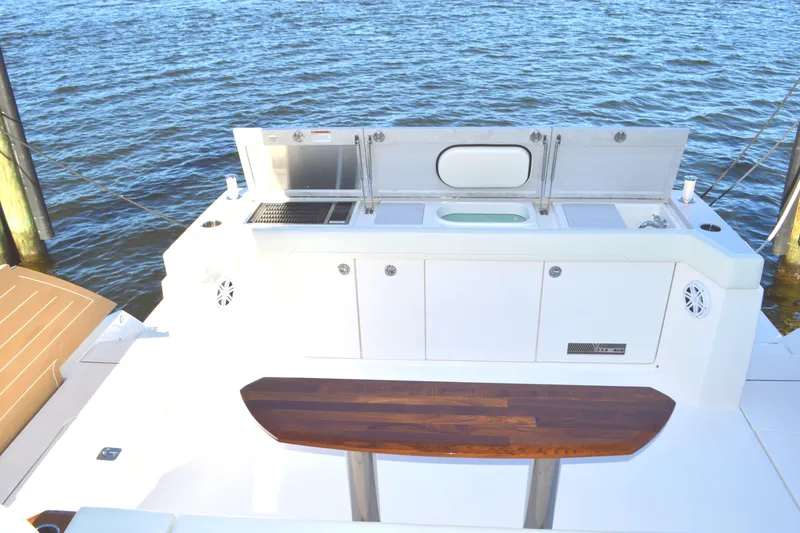 Slide: The Image of 2024 Tiara Yachts EX 60 outdoor kitchen with grill and sink by the water. - 23