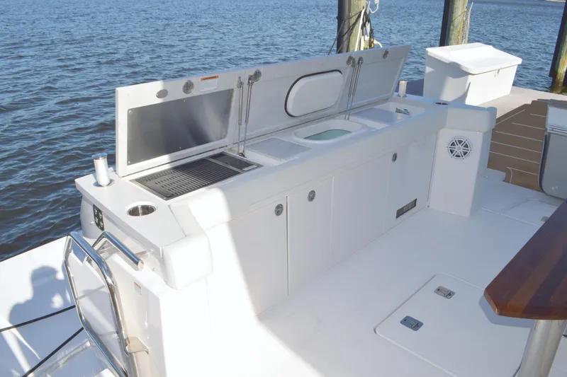 Slide: The Image of Outdoor kitchen on 2024 Tiara Yachts EX 60, featuring grill and sink by the water. - 25