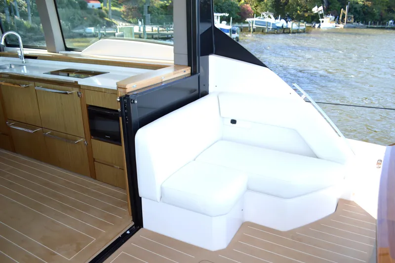 Slide: The Image of 2024 Tiara Yachts EX 60 interior with kitchen and seating area by the water. - 32