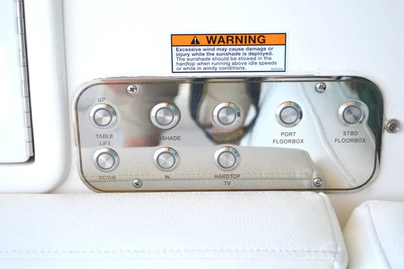Slide: The Image of Control panel on 2024 Tiara Yachts EX 60 with various function buttons and warning label. - 36