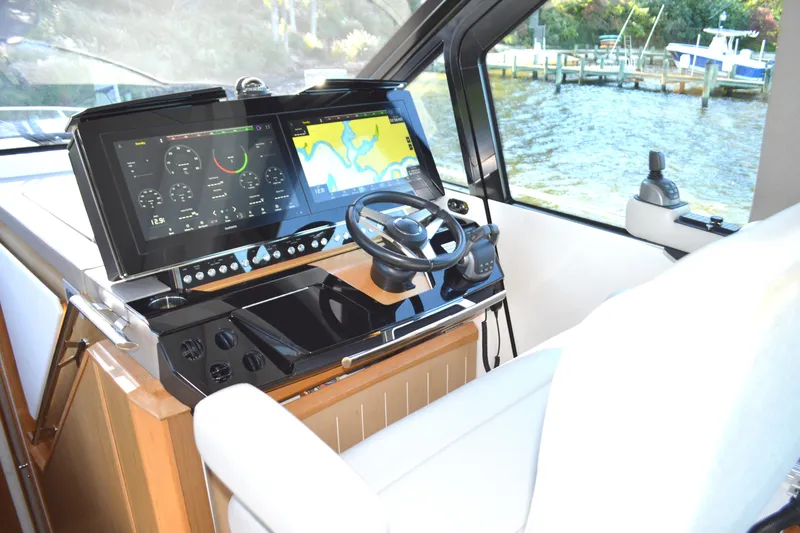Slide: The Image of 2024 Tiara Yachts EX 60 helm with advanced navigation displays and steering wheel. - 37