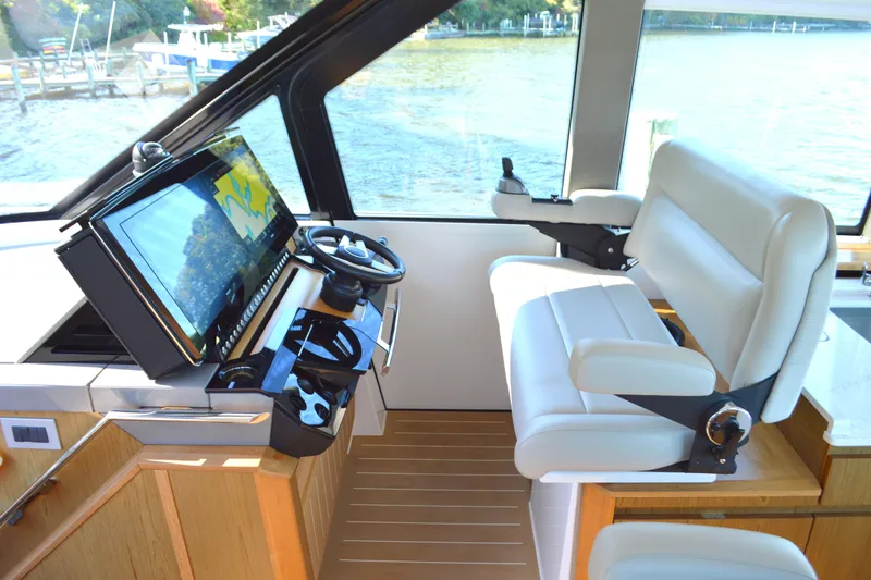 Slide: The Image of 2024 Tiara Yachts EX 60 helm with modern controls and luxurious seating. - 38