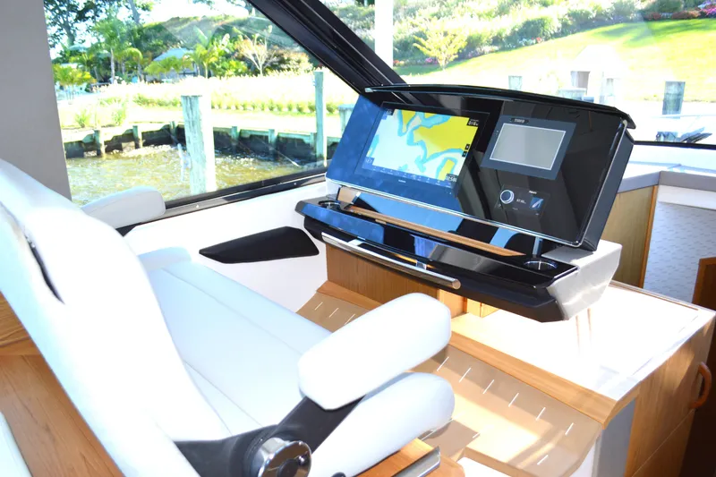 Slide: The Image of 2024 Tiara Yachts EX 60 helm with advanced navigation display and luxurious seating. - 41