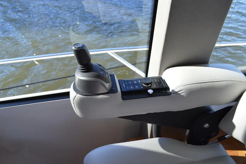 Slide: The Image of 2024 Tiara Yachts EX 60 helm control, featuring joystick and control panel, overlooking water. - 43