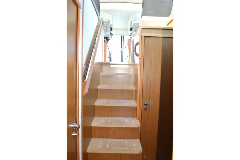 Slide: The Image of Staircase inside 2024 Tiara Yachts EX 60, featuring sleek wooden design and modern finish. - 54