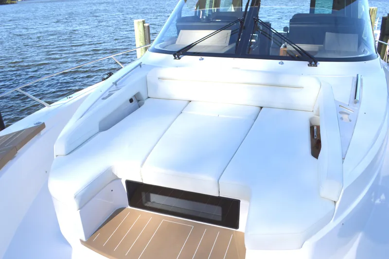 Slide: The Image of 2024 Tiara Yachts EX 60 deck with luxurious seating by the water. - 7