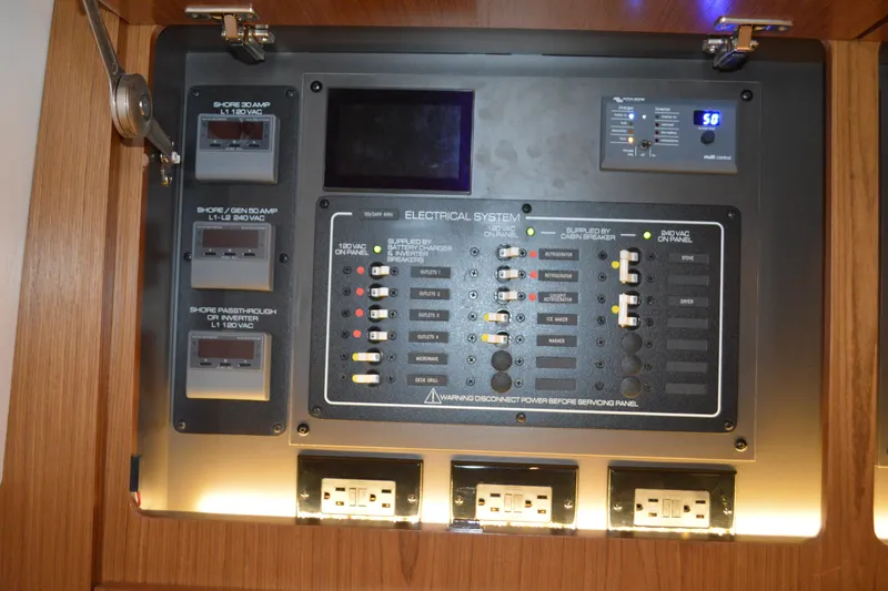 Slide: The Image of Electrical control panel on 2024 Tiara Yachts EX 60, featuring various switches and outlets. - 85