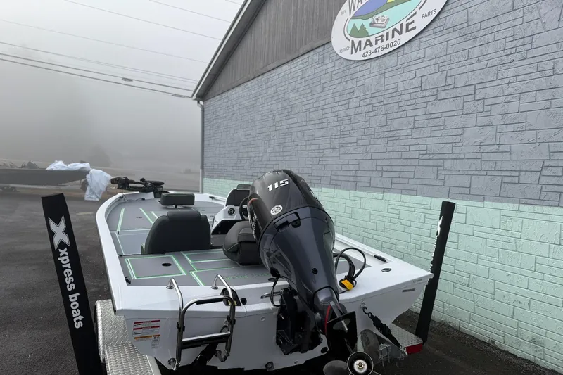 Slide: The Image of 2026 Xpress H18 boat with 115 horsepower engine, parked outside a marine shop. - 10
