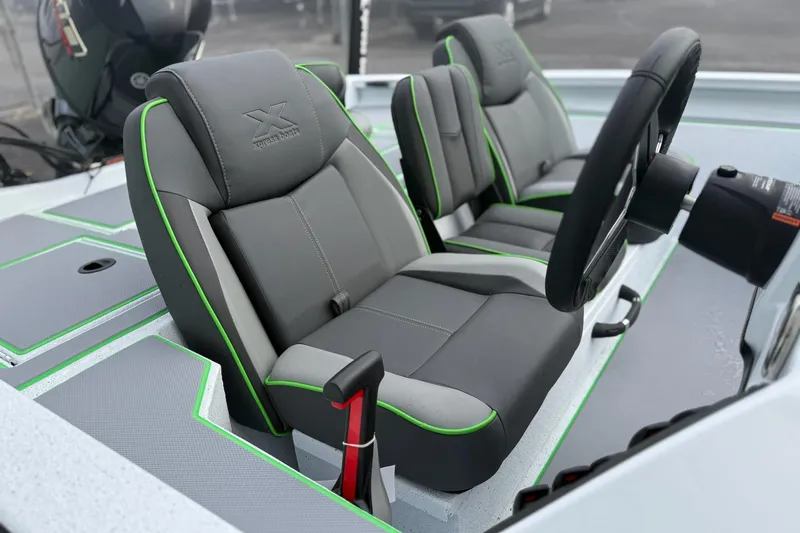 Slide: The Image of 2026 Xpress H18 boat interior with gray and green seats, steering wheel visible. - 7
