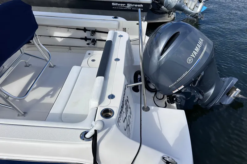 Slide: The Image of 2019 Robalo R222 Explorer with Yamaha outboard motor, docked on calm water. - 11