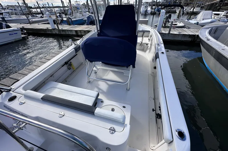 Slide: The Image of 2019 Robalo R222 Explorer boat interior at marina, featuring seating and storage. - 13
