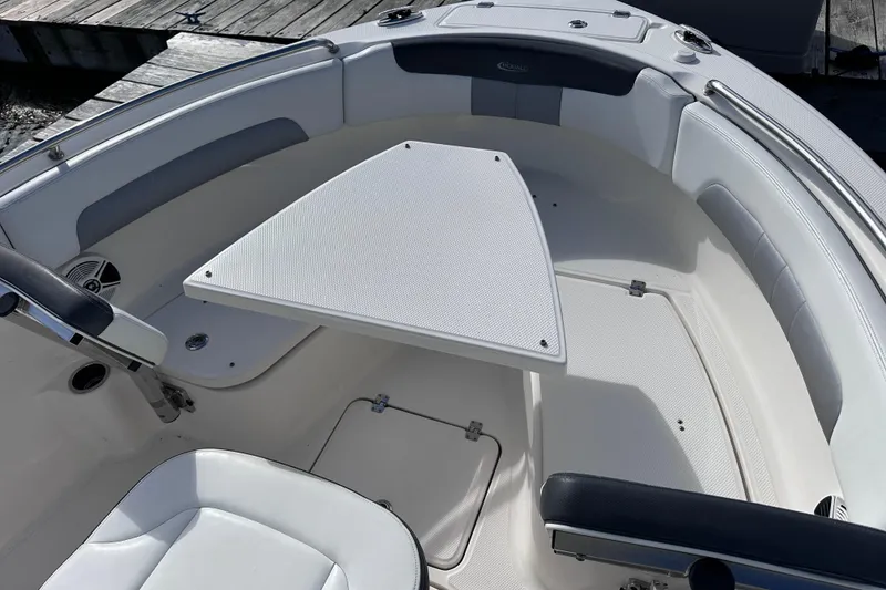 Slide: The Image of 2019 Robalo R222 Explorer boat interior with seating and table, dockside view. - 27