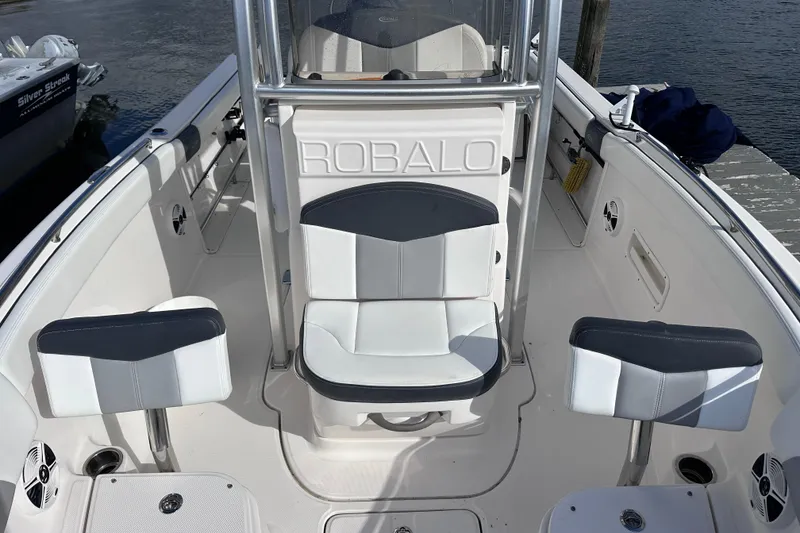 Slide: The Image of 2019 Robalo R222 Explorer boat interior with seating and console, docked by the water. - 29