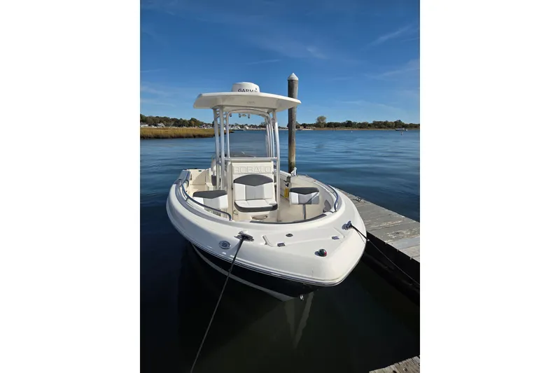 Slide: The Image of 2019 Robalo R222 Explorer boat docked on calm water under clear blue sky. - 4