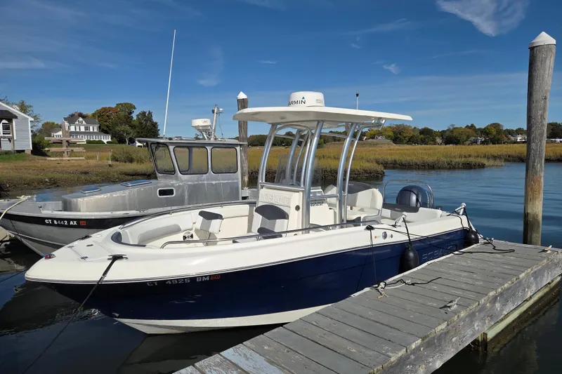 Slide: The Image of 2019 Robalo R222 Explorer boat docked by a serene waterfront. - 5