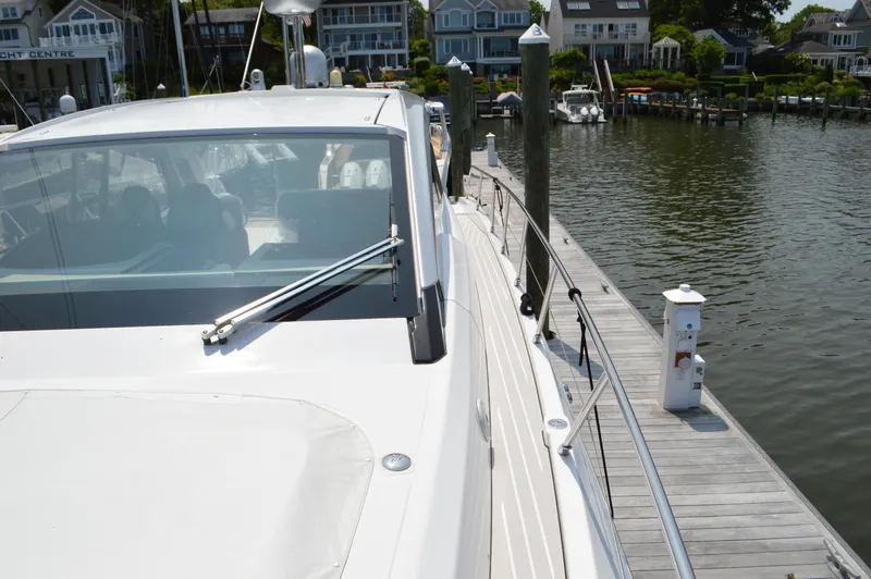 Slide: The Image of 2019 Azimut Atlantis 51 yacht docked at a marina, showcasing sleek design and waterfront homes. - 29