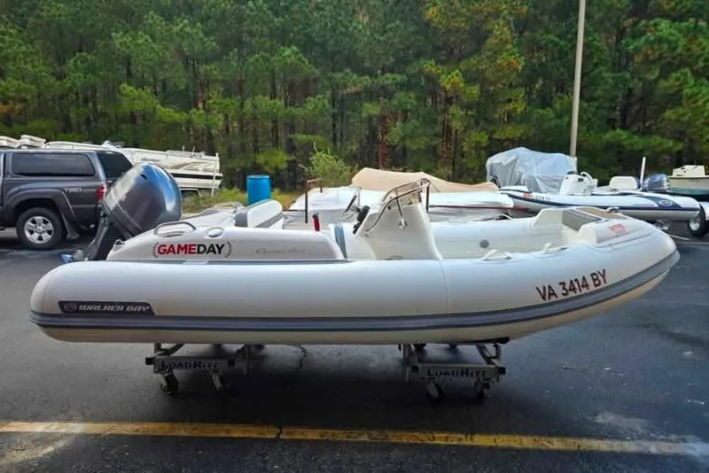 Slide: The Image of 2013 Walker Bay Generation 400 DLX inflatable boat on trailer, parked outdoors. - 2