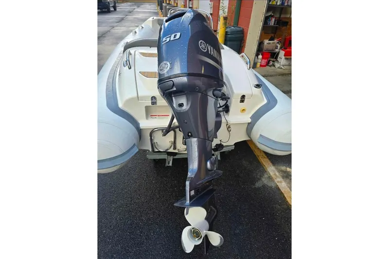 Slide: The Image of 2013 Walker Bay Generation 400 DLX with Yamaha 50 outboard motor, parked on wet pavement. - 4