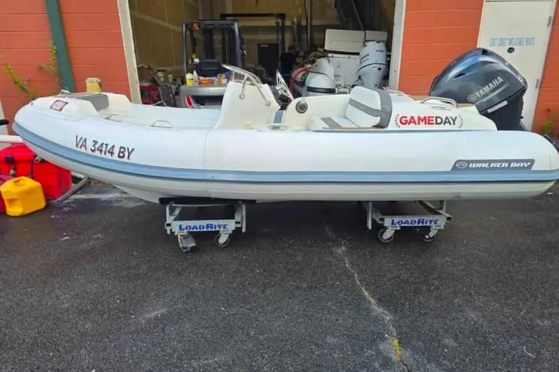 Slide: The Image of 2013 Walker Bay Generation 400 DLX inflatable boat on LoadRite trailer, parked outdoors. - 6