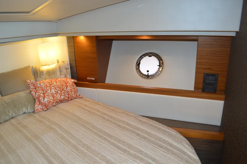 Slide: The Image of 2019 Tiara Yachts C39 Coupe cabin interior with bed, porthole, and modern decor. - 46