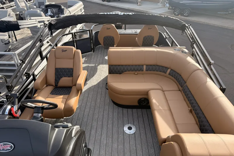 Slide: The Image of 2026 Ranger 220F boat interior with tan and black seating, featuring a steering console. - 8