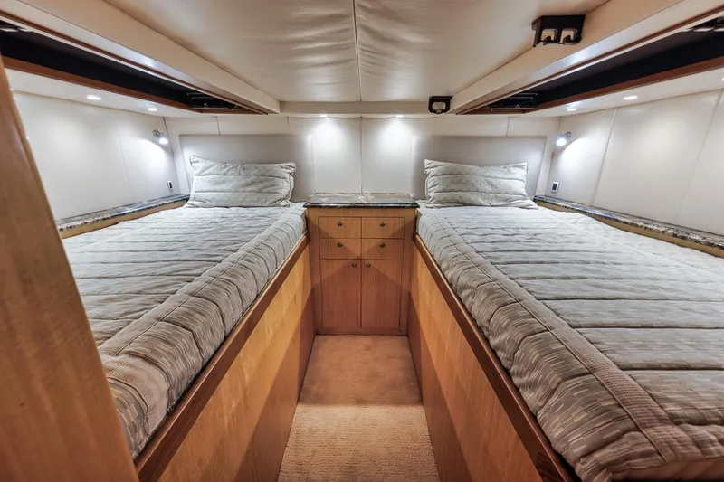 Slide: The Image of 2012 Spencer Yachts Express cabin with twin beds, modern lighting, and wooden cabinetry. - 25