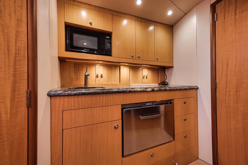 Slide: The Image of Luxurious 2012 Spencer Yachts Express interior with kitchenette, seating, and wood finishes. - 34