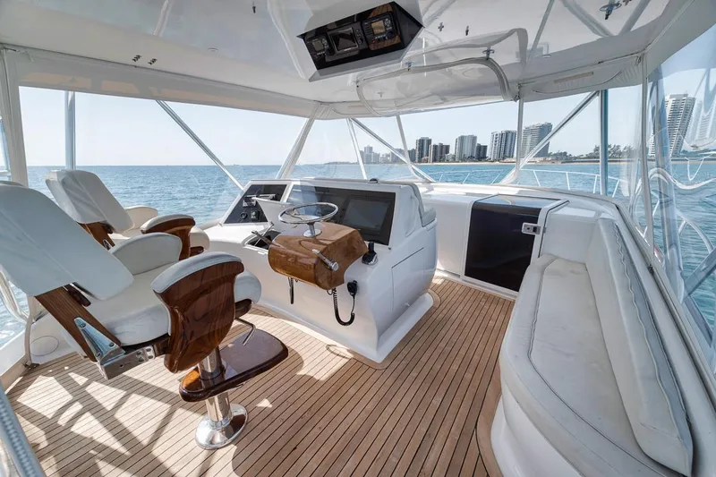 Slide: The Image of 2012 Spencer Yachts Express helm with ocean view, featuring modern navigation equipment and wooden steering wheel. - 45