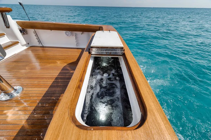 Slide: The Image of 2012 Spencer Yachts Express with teak deck and livewell, cruising on clear blue ocean. - 43