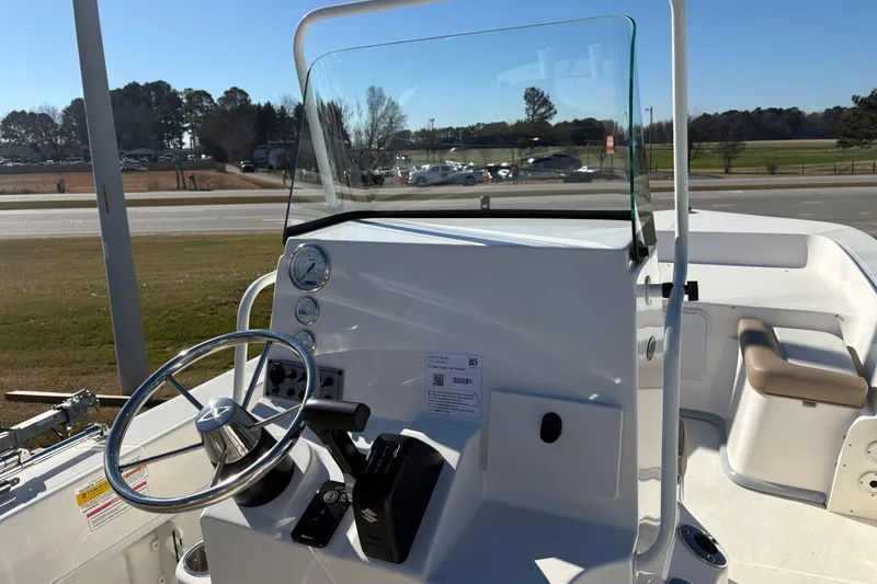 Slide: The Image of 2026 Sundance B20CCR boat console with steering wheel and gauges, parked outdoors. - 11