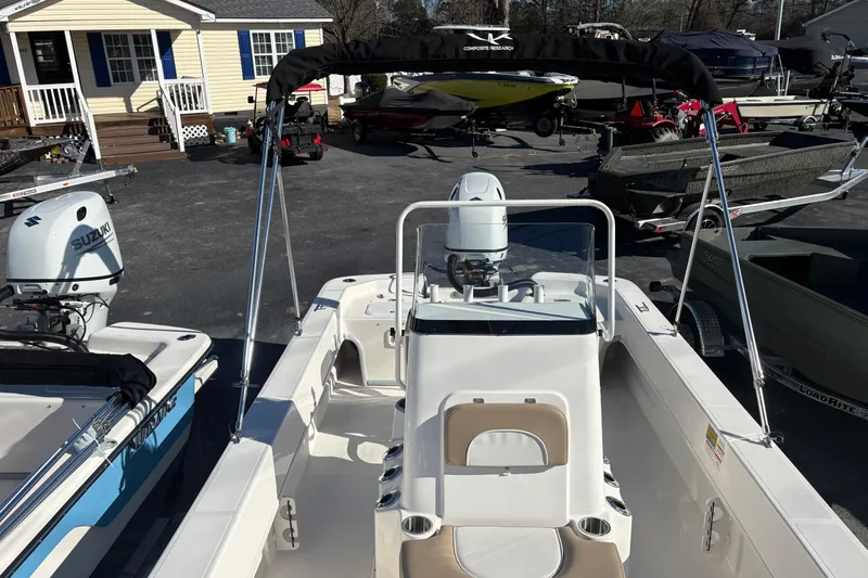 Slide: The Image of 2026 Sundance B20CCR boat with Suzuki outboard motor, parked near a house. - 7