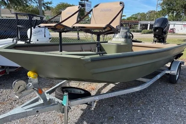 The Image of 2026 SeaArk 1860 MV boat on trailer, featuring dual seats and outboard motor. - 1