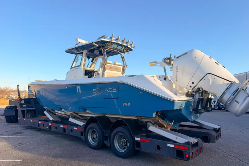 Slide: The Image of Solace 32 CS 2026 on trailer, blue hull, dual outboard engines. - 3